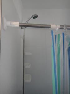 a shower rod with a shower head and toothbrushes at Beaulieu in Piriápolis +27 photos