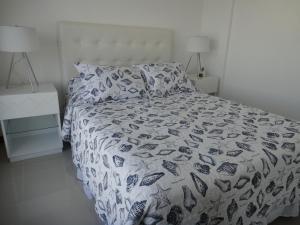 a bedroom with a bed with a black and white comforter at Beaulieu in Piriápolis