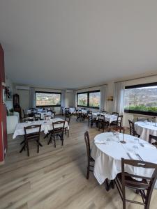 a dining room with tables and chairs and windows at Ristorante Le Rasole in Garda
