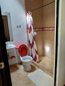 a bathroom with a red and white shower curtain and a toilet at Finca Montenegro Quindio in Montenegro +9 photos