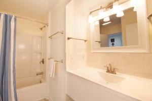 a white bathroom with a sink and a mirror at 611 Magnolia-Stella Maris in Edisto Island +68 photos