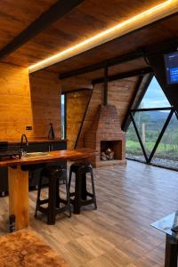 a kitchen with a large wooden table and a fireplace at Chalet - Laguna de la Cocha in Pasto