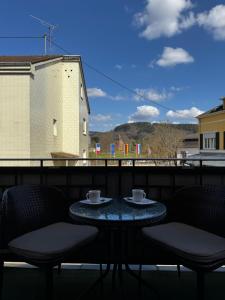 a table with two cups and chairs on a balcony at Gästehaus Flair in Mettlach