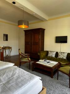 a bedroom with a bed and a couch and a table at Gästehaus Flair in Mettlach