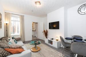 a living room with a couch and a table at Bright & Comfortable 2-Bed Home 5 mins from Newcastle City Centre - Free Parking in Gateshead