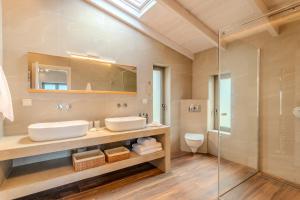 a bathroom with two sinks and a glass shower at Thalassori Villas in Agios Nikolaos