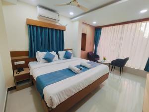 a bedroom with a large bed with blue pillows at Hotel Elite Walker Town in Hyderabad