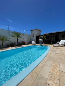 a swimming pool in a yard with a patio at Casa temporada frances in Marechal Deodoro