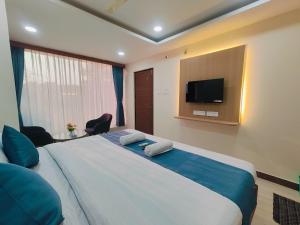 a bedroom with a large bed and a flat screen tv at Hotel Elite Walker Town in Hyderabad