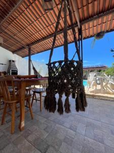 a dining room with a wooden table and a chandelier at Casa temporada frances in Marechal Deodoro