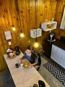 a woman sitting at a table in a restaurant at Cabanas Monte Belo in Santa Cruz do Sul