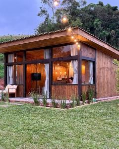 a house with a large window and a person sitting in it at Cabanas Monte Belo in Santa Cruz do Sul