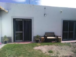 a white building with black doors and a chair at Mendoza Junín aceptamos tarjetas in Junín