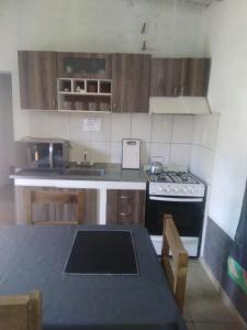 a kitchen with wooden cabinets and a stove and a table at Mendoza Junín aceptamos tarjetas in Junín