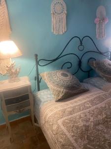 a bedroom with a bed with a blue wall at Le PHoenix in Roquestéron