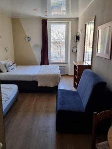 a room with two beds and a couch and a chair at L'Auberge d'Eygliers in Eygliers