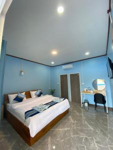 a bedroom with a large bed with a blue wall at Khaosok Bluesky Hotel in Khao Sok National Park