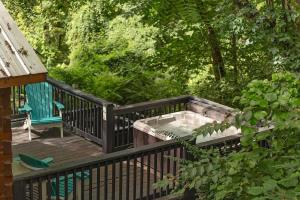 a deck with a hot tub and a chair on it at Ani Cabin Tiny Home Bordered By National Forest in Chattanooga +31 photos