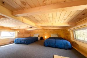 two beds in a room in a log cabin at Ani Cabin Tiny Home Bordered By National Forest in Chattanooga