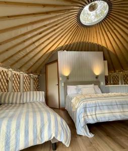 a bedroom with two beds and a ceiling at Yurts at Yelverton in Yelverton