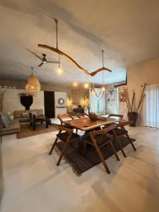 a dining room with a table and a living room at Casa Nikau Chic Getaway in El Cuyo in El Cuyo