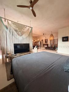 a bedroom with a large bed with a ceiling fan at Casa Nikau Chic Getaway in El Cuyo in El Cuyo