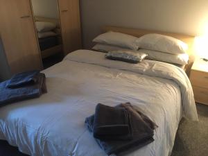 a bedroom with a bed with two towels on it at Lakeside Apartment in Enniskillen