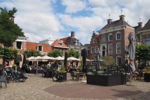 a courtyard with tables and chairs and umbrellas at Molesicht en Lânsicht in Workum