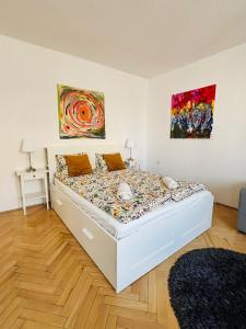 a bed in a bedroom with a painting on the wall at Gdynia Abrahama 48 in Gdynia