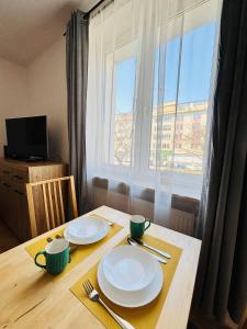 a wooden table with plates on it with a window at Gdynia Abrahama 48 in Gdynia