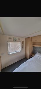 a bedroom with a large bed and a window at Coastal Getaway, camber sands in Camber