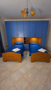 two beds in a room with blue cabinets at La Francigena in Vetralla