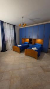 a room with two beds and blue cabinets at La Francigena in Vetralla