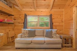 a living room with a couch in a log cabin at Peggers Cabin Luxury Rustic Tiny Cabin Spa in Chattanooga