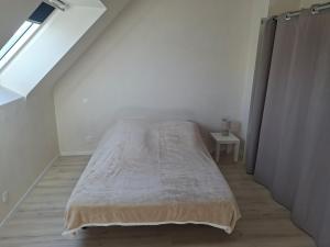 a bed in a white room with a window at Maison Du Bonheur in Erquy