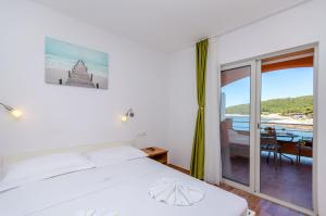 a bedroom with a bed and a view of the ocean at Apartments Juka in Milna