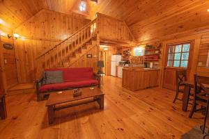 a living room with a red couch in a wooden cabin at Cherokee Ridge Cabin Near The Ocoee River in Ocoee
