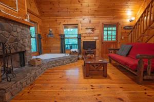 a living room with a fireplace and a red couch at Cherokee Ridge Cabin Near The Ocoee River in Ocoee