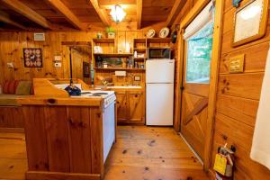 a kitchen with wooden cabinets and a white refrigerator at Creek Crest Cabin Ocoee Riverside Cabin in Ocoee