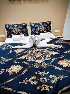a bed with a blue and gold blanket and pillows at Robert's Apartment in Celje