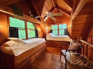 a bedroom with two beds in a wooden cabin at Ocoee Cabin Beautiful Cabin On The River's Edge in Ocoee