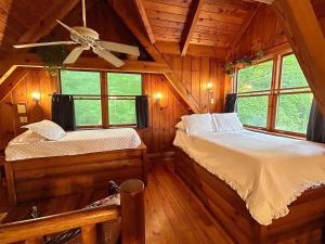 a bedroom with two beds and a ceiling fan at Ocoee Cabin Beautiful Cabin On The River's Edge in Ocoee +35 photos