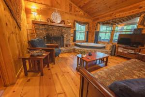 a living room with a fireplace in a cabin at The Pines Riverside Log Cabin On The Ocoee in Ocoee