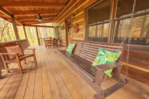a porch with a swing on a wooden house at The Pines Riverside Log Cabin On The Ocoee in Ocoee