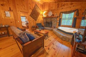 a living room with a fireplace and a tub in a cabin at The Pines Riverside Log Cabin On The Ocoee in Ocoee
