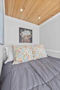 a bedroom with a bed with a picture of a cow at Quail Run Farm- Rustic Tiny Home 1 in Chattanooga +23 photos