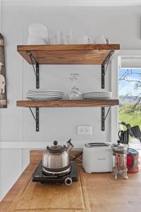 a kitchen with wooden shelves and a pot on a stove at Quail Run Farm- Rustic Tiny Home 1 in Chattanooga