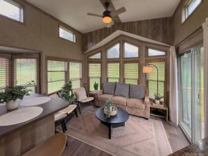 a living room with a couch and tables and windows at Quail Run Farm- Rustic Tiny Home 3 in Chattanooga