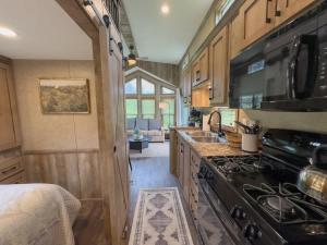 a kitchen with a stove and a sink at Quail Run Farm- Rustic Tiny Home 3 in Chattanooga