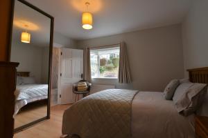 a bedroom with a bed and a large mirror at An Grianán Getaway in Burt